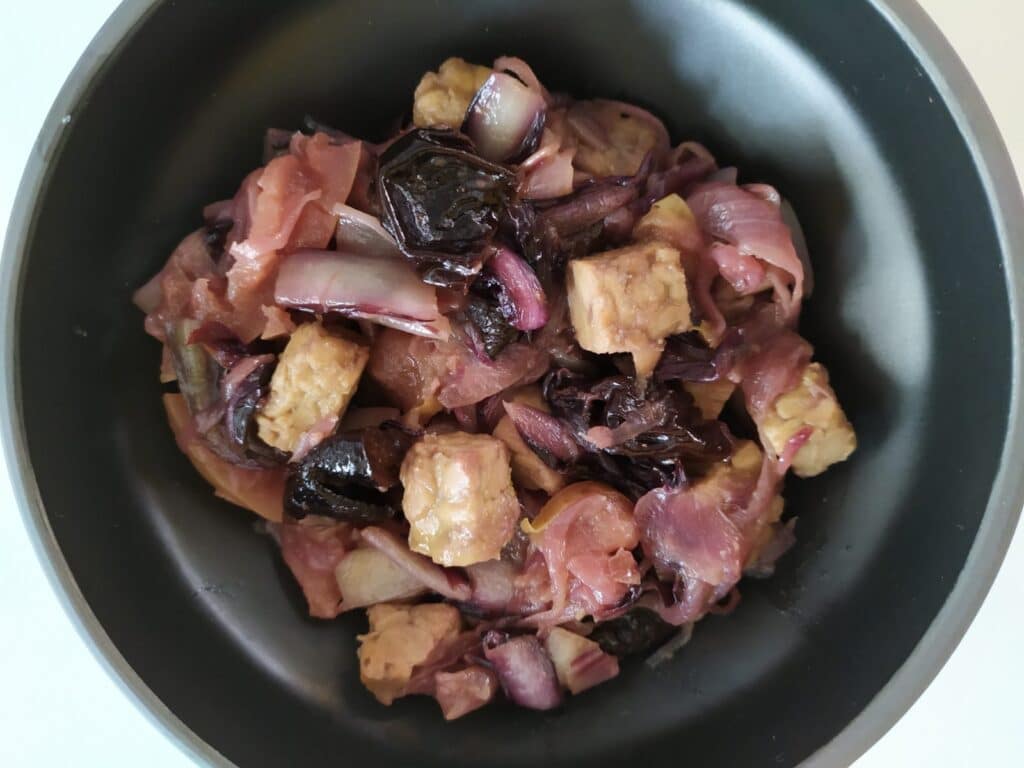 Tempeh marinato con stufato di radicchio, cipolle, mele e prugne