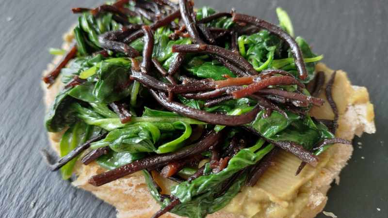 Crostino con hummus di edamame e avocado, spinacini e alghe hijiki